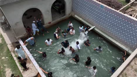 Luftaufnahme-Männlicher-Freunde,-Die-Im-Ländlichen-Sindh-Einen-Swimmingpool-Genießen