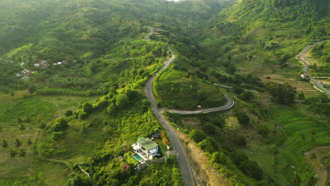 Aerial-flyover-lush-green-landscape-in-Lombok-riding-motorcycles-on-mountain-road-during-foggy-sunrise,-Indonesia
