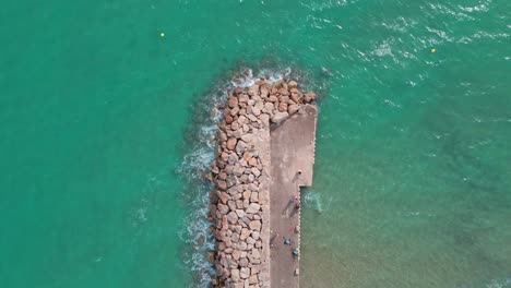 Aerial-4K-drone-footage-of-rocky-pier-in-El-Roc-de-Sant-Gaietà,-a-scenic-location