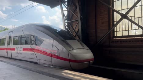 Slow-motion-shot-of-German-ICE-Express-Train-Leaving-Train-station-in-Hamburg-during-sunny-day-with-clouds-at-sky---establishing-shot