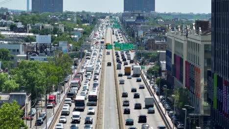 Aerial-view-of-busy-highway-in-Brooklyn-District-During-sunny-day-in-New-York-City,-USA---Descending-long-zoom-lens-drone-shot
