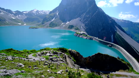 2-Personas-Irreconocibles-Caminando-Por-El-Sendero-Junto-Al-Lago-Y-La-Montaña-En-Austria