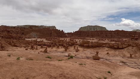 A-woman-walks-along-a-hiking-trail-in-the-Mars-like-landscape-of-Goblin-Valley-State-Park-in-Utah