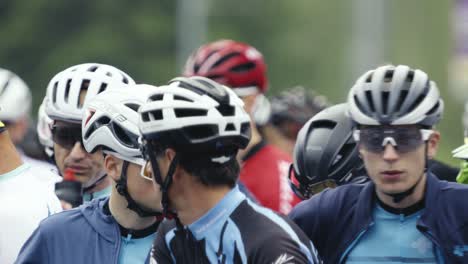 Nahaufnahme-Einer-Gruppe-Behelmter-Rennfahrer,-Die-Nervös-Auf-Den-Start-Eines-Radrennens-Warten