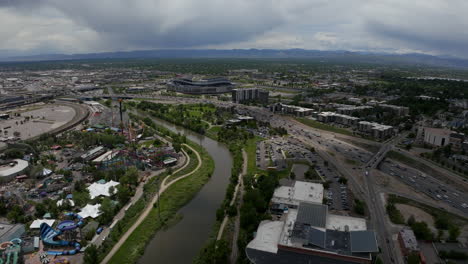 Downtown-Denver-Aerial-Drone-cinematic-Mile-High-Stadium-South-Platte-River-Elitch-Gardens-cityscape-with-foothills-Rocky-Mountain-Landscape-Colorado-cars-traffic-spring-summer-forward-movement
