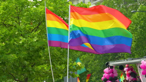 LGBT-flags-raised-on-a-wooden-arbor-mowed-in-the-wind-by-people-holding-them-in-their-hands