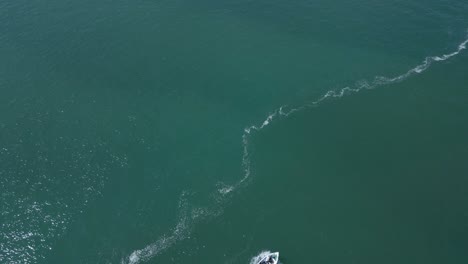Aerial-view-of-a-boat-in-the-Atlantic-Ocean,-Troia-island-near-of-Arrabida-Natural-Park,-Portugal
