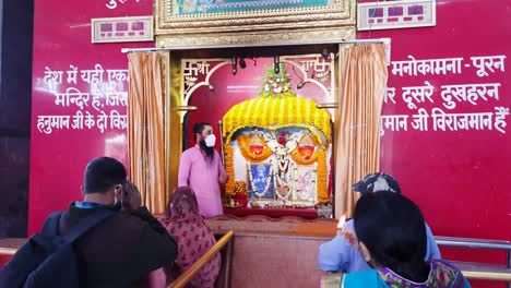people-offering-to-hindu-god-hanuman-statue-decorated-with-flowers-from-flat-angle-video-is-taken-mahavir-temple-patna-bihar-india-on-Apr-15-2022