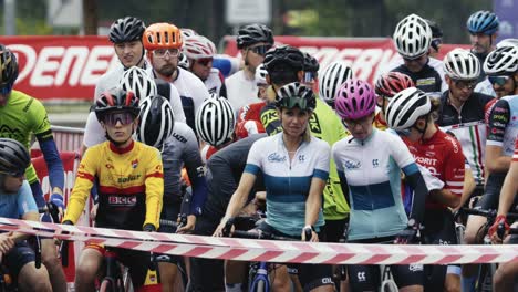 Slow-motion-shot-of-a-group-of-male-and-female-racers-waiting-for-the-start-of-a-road-cycling-race