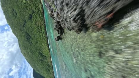 Vertical-fpv-flight-over-coral-reef-with-rocks-and-beach-of-PLAYA-ERMITAÑO-in-summer,-Dominican-Republic---Spectacular-flight-along-coastline
