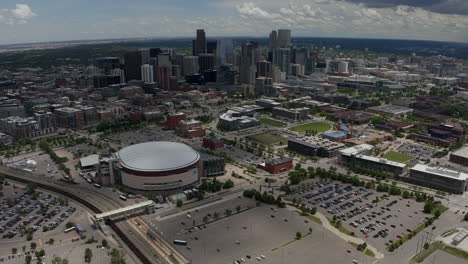 Downtown-Denver-Aerial-Drone-cinematic-REI-Ball-Arena-South-Platte-River-Elitch-Gardens-cityscape-with-foothills-Rocky-Mountain-Landscape-Colorado-cars-traffic-spring-summer-forward-pan-up-movement