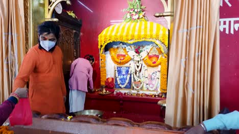 people-offering-to-hindu-god-hanuman-statue-decorated-with-flowers-from-flat-angle-video-is-taken-mahavir-temple-patna-bihar-india-on-Apr-15-2022