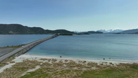 Sandvika-and-Gjerdesanden-beach-with-Giske-bridge-in-background-at-Alesund-Norway---Happy-families-and-children-on-the-beach-in-beautiful-summer-coastal-landscape---Aerial-view