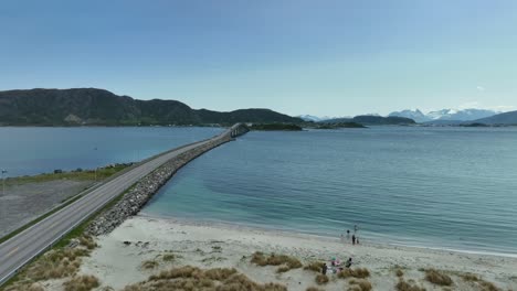 Sandvika-Und-Gjerdesanden-Strand-Und-Neben-Der-Giske-Brücke-In-Ålesund-Norwegen---Glückliche-Familien-Und-Kinder-Am-Strand-In-Wunderschöner-Sommerküstenlandschaft---Rückwärts-Bewegte-Luftaufnahme