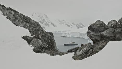 Big-expedition-ship-or-boat-sitting-in-a-bay-in-Antarctica,-dolly-shot