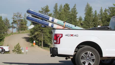 Farbige-Paddle-Boards,-Die-Auf-Der-Rückseite-Eines-Geparkten-Weißen-4x4-Lastwagens-Gelagert-Sind