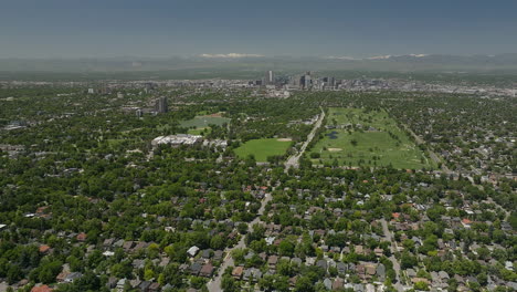 Downtown-Denver-homes-City-Park-museum-Golf-Course-cityscape-Rocky-Mountain-landscape-14ers-Mount-Evans-aerial-drone-cinematic-foothills-Colorado-spring-summer-green-lush-circling-left-movement