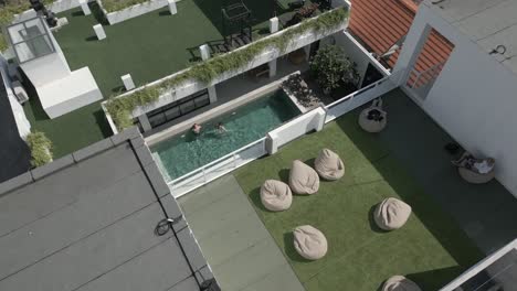 Flyover:-Caucasian-tourists-enjoy-sunny-outdoor-pool-in-Bali-resort