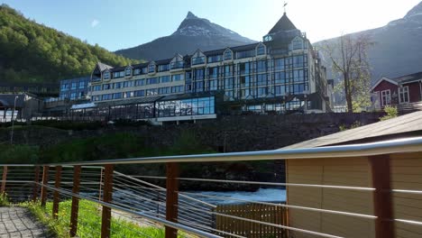 Hotel-union-seen-behind-river-of-tourist-walkway-with-railings-in-stunning-Geiranger-Norway---Handheld-stabilized-tourists-pov