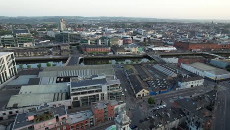 Right-panning-establishing-aerial-shot-of-Cork-city-reveals-golden-sunset,-4K
