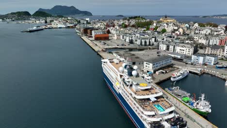 Luxury-cruise-ship-SH-Diana-alongside-in-Alesund-Norway---High-angle-aerial-with-tilt-up-to-reveal-full-city-and-Atlantic-ocean-view