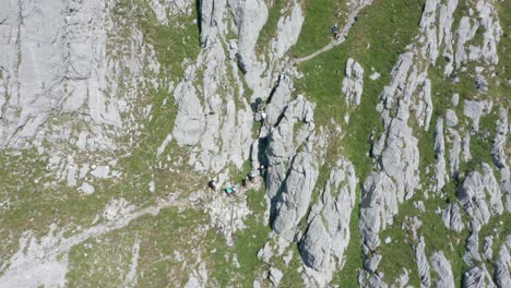 Aerial-of-group-of-climbers-climbing-up-a-mountain-ledge