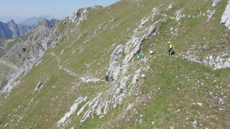 Aerial-of-group-of-climbers-walking-past-a-ledge-on-a-high-and-rough-mountain
