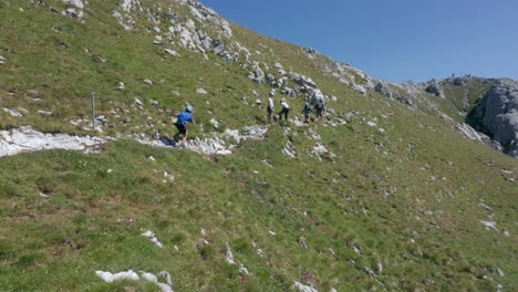 Kid-running-behind-a-group-of-climbers-on-a-narrow-mountain-path