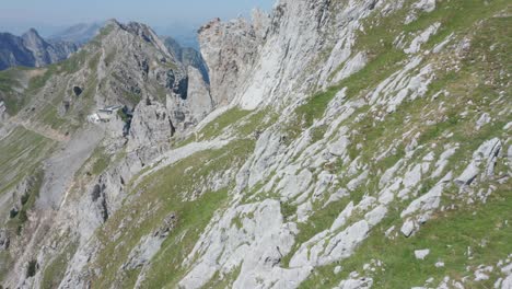 Drohne-Fliegt-An-Einer-Felsigen-Bergwand-Vorbei-Und-Enthüllt-Eine-Gruppe-Von-Kletterern