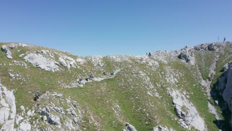 Drohne-Fliegt-Auf-Eine-Gruppe-Von-Bergsteigern-Zu,-Die-Auf-Einem-Hohen-Berg-Bergab-Gehen