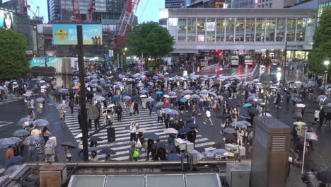 TOKYO,-JAPAN---APRIL-8,-2023:-View-of-Shibuya-Crossing,-one-of-the-busiest-crosswalks-in-the-world-in-a-raining-day