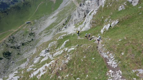 Aerial-of-group-of-mountaineers-hiking-uphill-and-revealing-a-beautiful-landscape