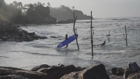 Surfistas-Caminando-Hacia-El-Océano-Y-Surfeando-En-La-Costa-De-Weligama-Con-Zancos-De-Madera-En-Matara,-Sri-Lanka