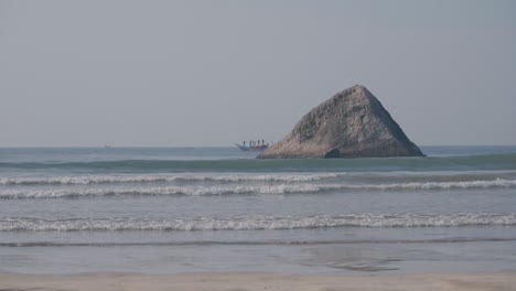 Los-Pescadores-En-Un-Barco-De-Pesca-Navegando-En-El-Océano-Azul-Revelan-Más-Allá-De-La-Formación-Rocosa-En-La-Playa-De-Weligama,-Sri-Lanka