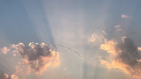 Wolkenlandschaft-Mit-Himmlischem-Sonnenuntergang-Und-Darüber-Fliegendem-Vogelschwarm