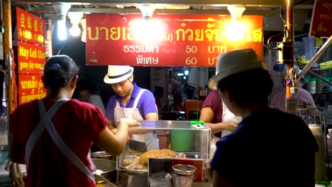 Customers-And-Vendors-In-A-Street-Food-Stall-In-Chinatown,-Bangkok,-Thailand-At-Night---medium-shot