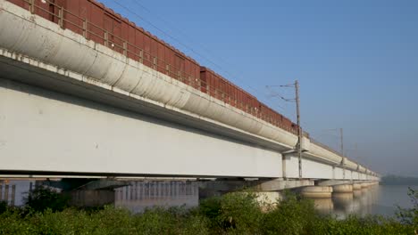 Lokalzug-Fährt-Und-überquert-Tagsüber-Die-Brücke-über-Den-Ruhigen-Fluss-In-Mumbai,-Indien