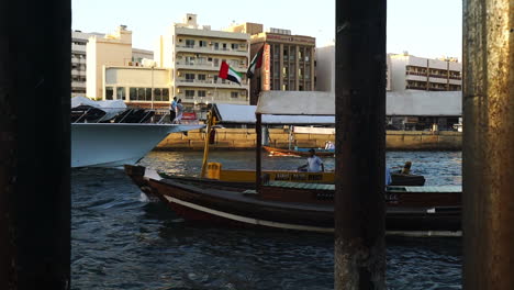 Abra-Water-Taxi-Cruising-At-The-Dubai-Creek-In-Deira,-Dubai,-UAE---medium-shot