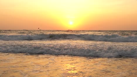 The-beautiful-fiery-sunset-over-the-waves-of-Goa,-India---wide