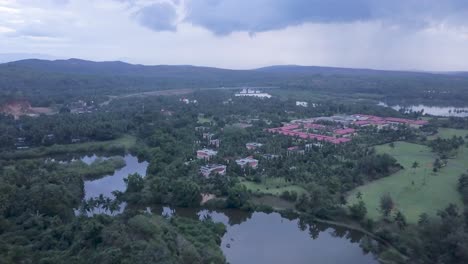 Drone-Flying-Towards-The-LaLiT-Golf-And-Spa-Resort-In-Raj-Baga,-Palolem,-Canacona,-Goa,-India-On-A-Cloudy-Day---aerial-drone-shot