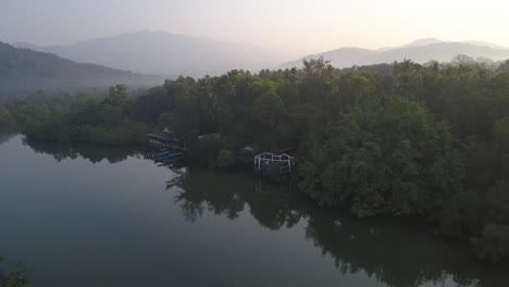 Scenic-View-At-The-Palolem-Beach,-Canacona-In-South-Goa,-India-Composed-Of-Green-Trees-and-Calm-Water-With-Mountain-At-The-Background---Aerial-Shot