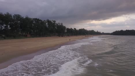 Beautiful-Sea-Waves-Breaking-On-Shore-At-Rajbagh-Beach,-Canacona,-South-Goa,-India---aerial-static-shot