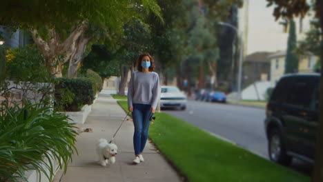 [Camera-Used:-Canon-C300]-Caucasian-woman-wearing-a-surgical-face-mask-while-outside-walking-her-dog