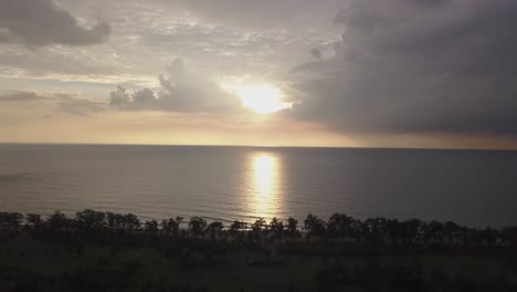 Vista-De-Una-Espectacular-Puesta-De-Sol-Con-Nubes-Oscuras---Hermosa-Puesta-De-Sol-Sobre-El-Mar-En-La-Playa-De-Rajbagh,-Canacona,-Sur-De-Goa,-India---Toma-Aérea-De-Drones