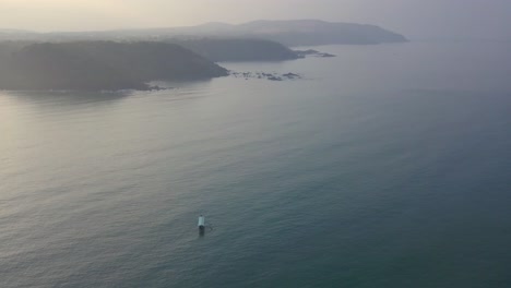 Schiff-Segelt-Auf-Dem-Ruhigen-Ozean-In-Der-Nähe-Des-Strandes-Von-Galgibaga-Mit-Nebligen-Bergen-Im-Hintergrund-Und-Blick-Auf-Das-Arabische-Meer-Im-Süden-Von-Goa,-Indien