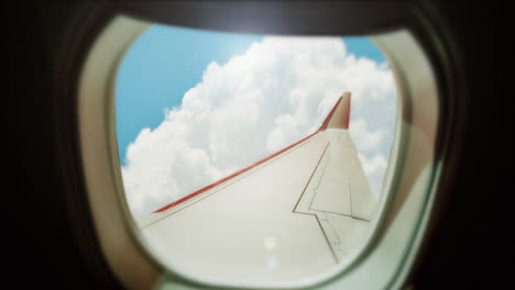 Airplane-window-shot-with-blue-skies-and-cloudscape-view