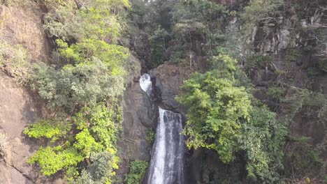 Jungle-Cascading-Down-From-Steep-Rocky-Valley-Of-Mainapi-Waterfall-In-Netravali-Taluka-Of-South-Goa,-India