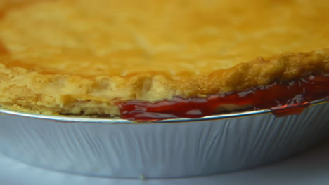 [Camera-Used:-Canon-C300]-Close-up-rotating-cherry-pie-crust,-with-cherry-glaze-oozing-out-the-sides