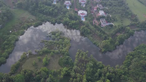 Scenic-View-Of-River-With-Reflections-of-Clouds-Near-Villas-In-The-LaLiT-Golf-And-Spa-Resort-Goa-In-India---aerial-drone-shot