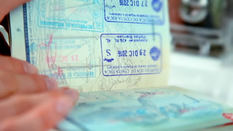 Woman-Turning-to-Page-with-Stamps-in-Canadian-Passport---At-24-fps